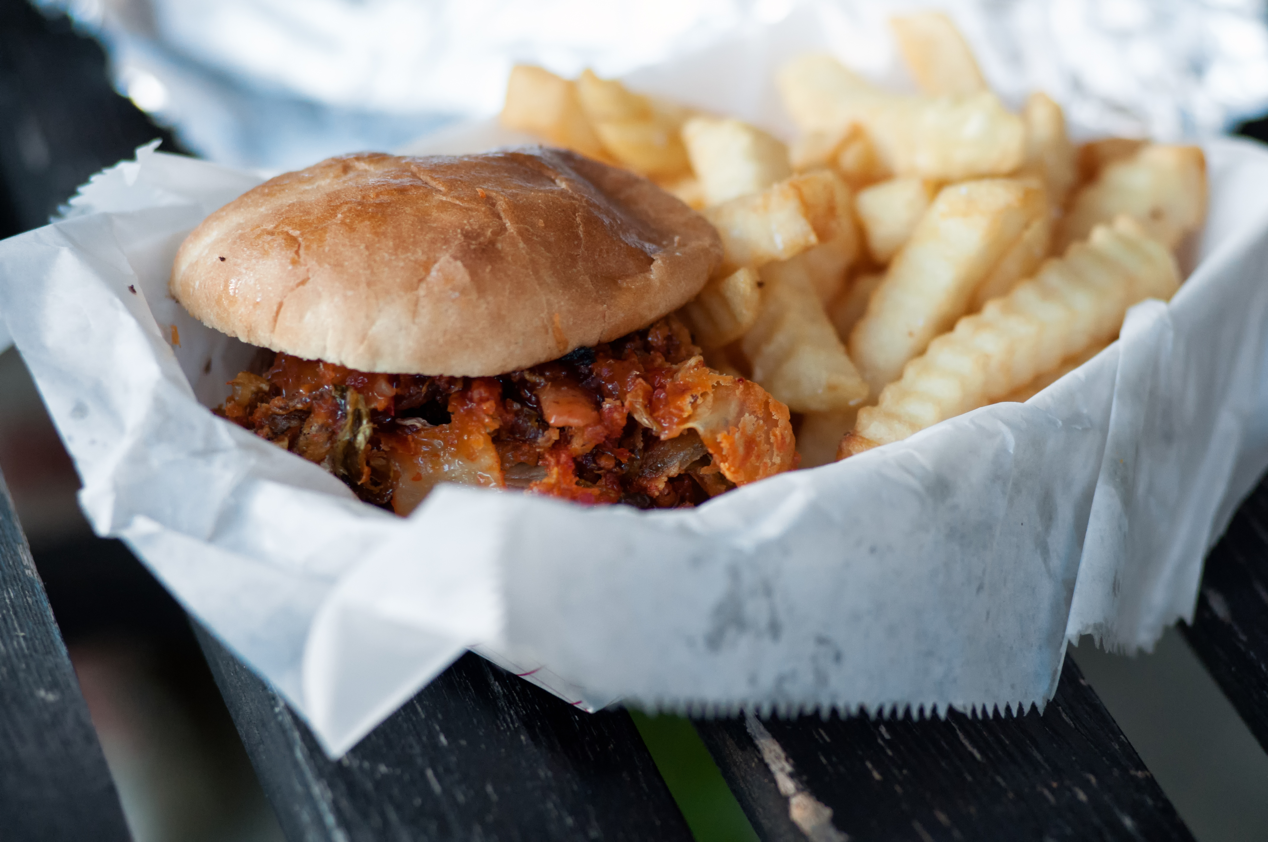 Sandwich and crinkle-cut fries in a paper-lined basket